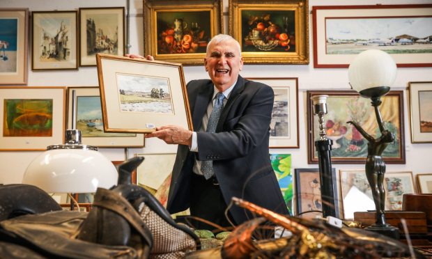 Ian Taylor holds up a watercolour by King Charles III which features in an upcoming auction. Mhairi Edwards/DC Thomson