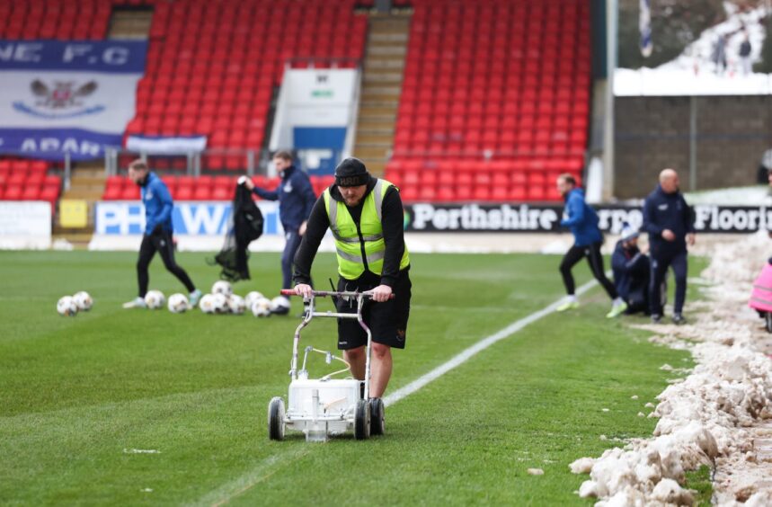 A member of the St Johnstone grounds staff paints the lines ahead of a game against Kilmarnock.