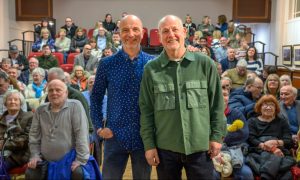 Steven Duncan and Barney Black at their film premier, standing in front of audience of former Muirton residents at Perth art gallery