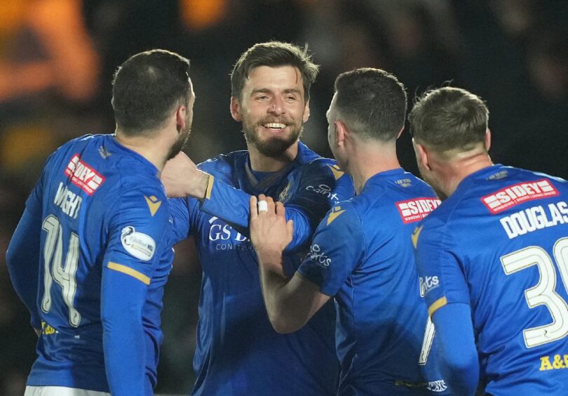 Graham Carey is congratulated by his team-mates.