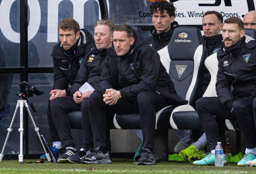 Dunfermline Athletic's staff and players sit on the bench.