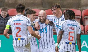 Dunfermline Athletic striker Chris Kane is surrounded by team-mates to celebrate his winning goal.