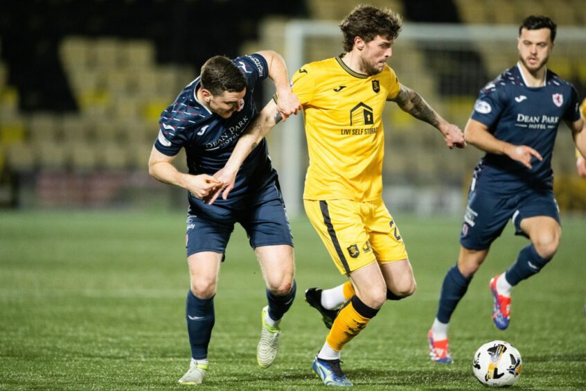 Raith Rovers defender Paul Hanlon and Jordan Doherty battle for possession with Livingston's Robbie Muirhead.