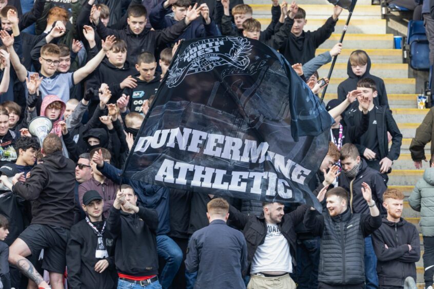 The Dunfermline Athletic ultras wave a flag in the away stand at the Falkirk Stadium.