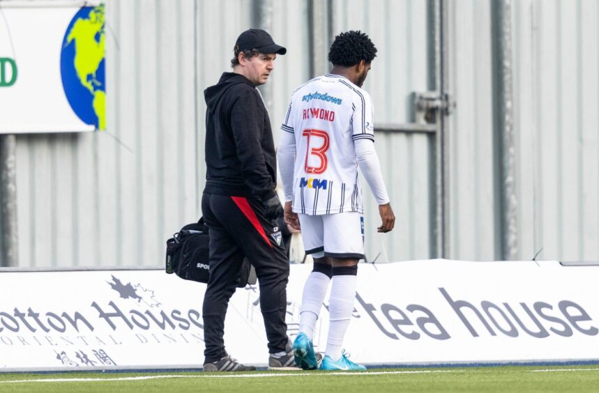 Dunfermline's on-loan St Johnstone defender Andre Raymond walks round the pitch disconsolately after succumbing to injury against Falkirk.