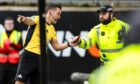 Referee Nick Walsh hands a missile that was thrown on to the pitch to a police officer during the Dundee derby. Image: Ross Parker/SNS