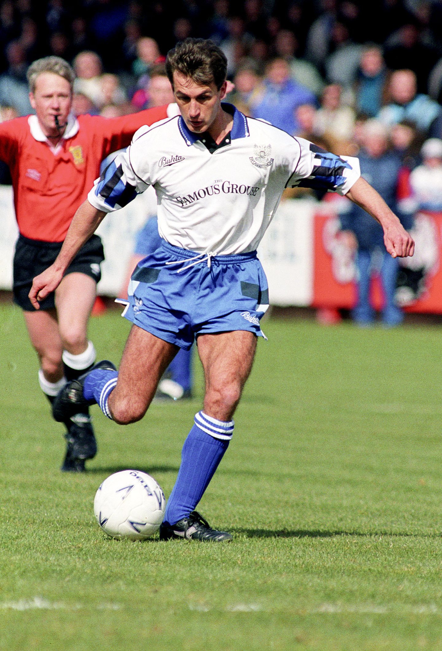 John Davies kicks the ball while playing for St Johnstone in April 1993, with the referee in the background