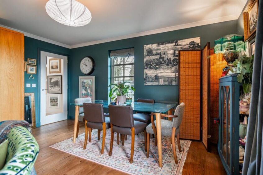 A dining table sits at the back of the living room.