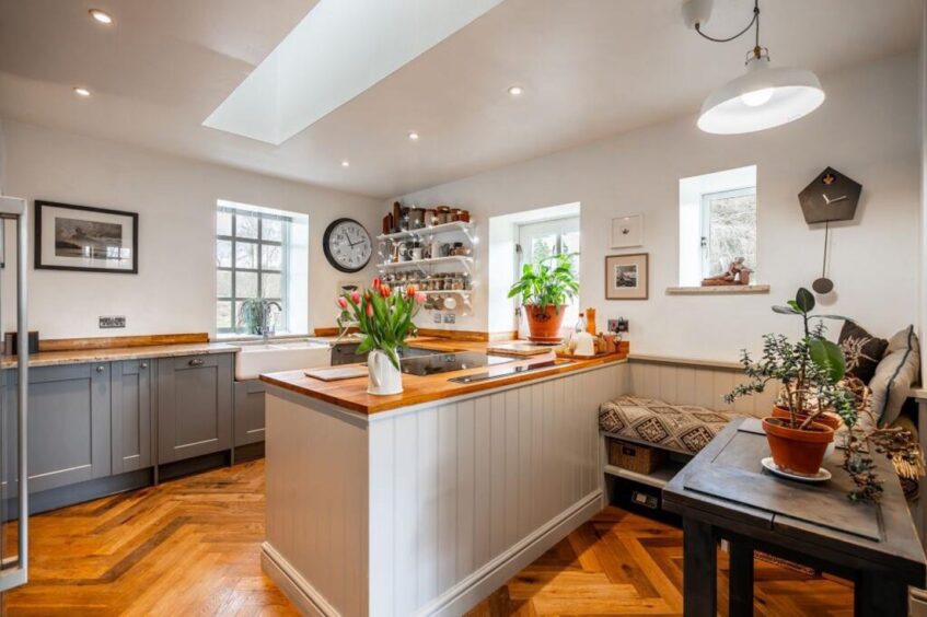 The kitchen features wood and marble worktops.