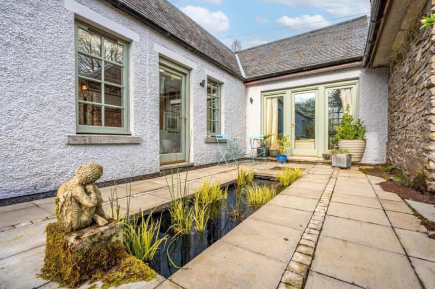 A pond sits in the courtyard garden at the Dunblane cottage 