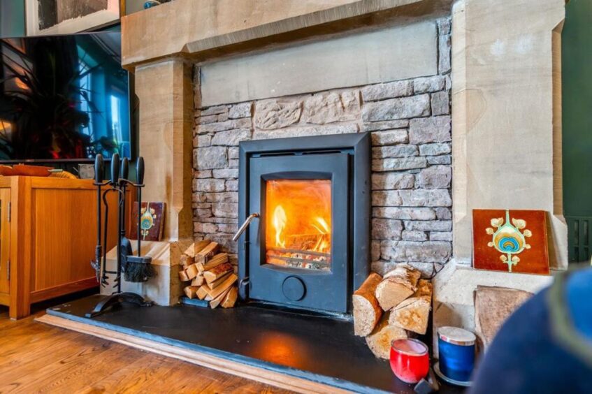 A wood burning stove sits at the heart of the living room.