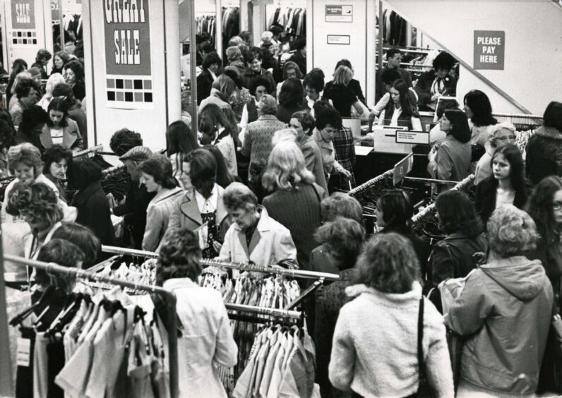 People browsing various racks of clothes in C&A's Dundee store in June 1973.