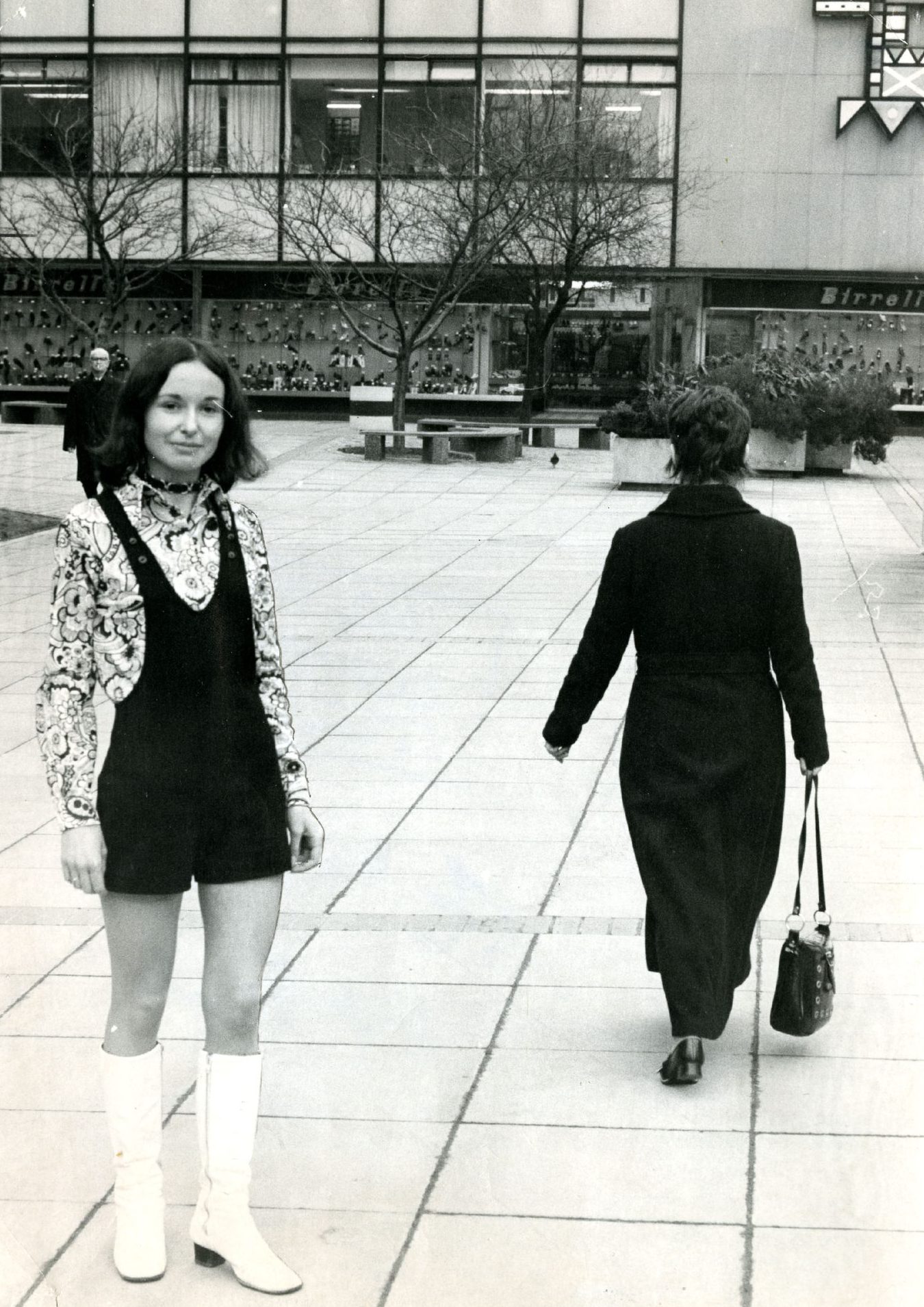 A woman posing in boots and a dress outside the Overgate in Dundee.