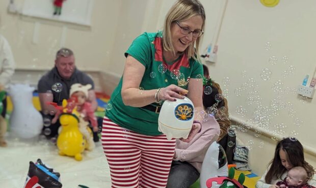 Kirsty Ross and families having fun with a bubble machine at Baby Sensory Stirling