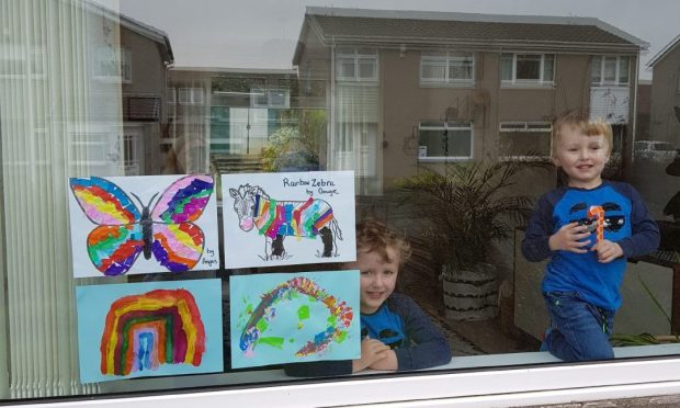 Brothers Angus and Dougie Farquharson from Broughty Ferry look out a window during the Covid lockdown.