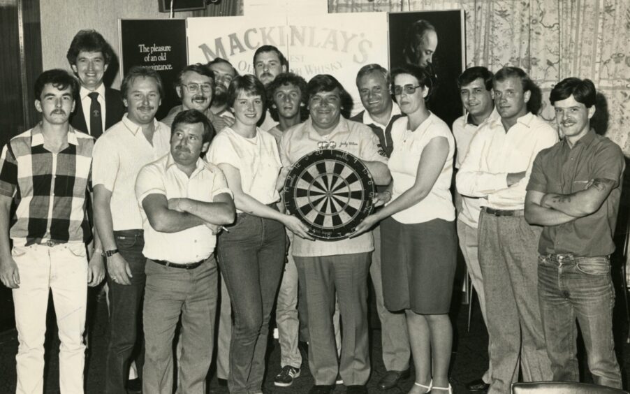 Jocky holds a dartboard as he is pictured at Dundee's Angus Hotel for a charity exhibition in 1984. 