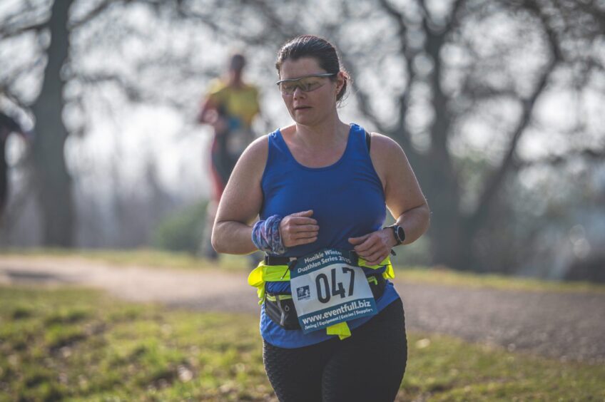 A woman running during the Winter Duathlon at Monikie Country Park