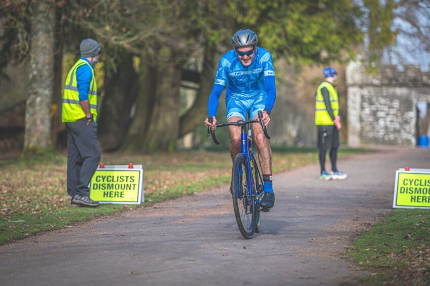 A cyclist smiles in the sunshine. 