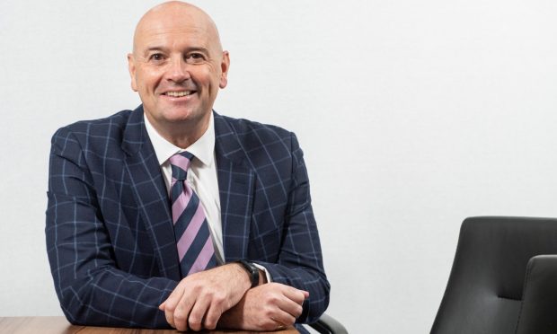 Aberdein Considine Perth boss Charlie Fraser sits at desk in his Perth office