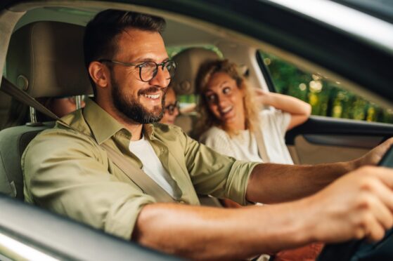 Man drives one of the latest electric car models as he goes on a road trip with his family