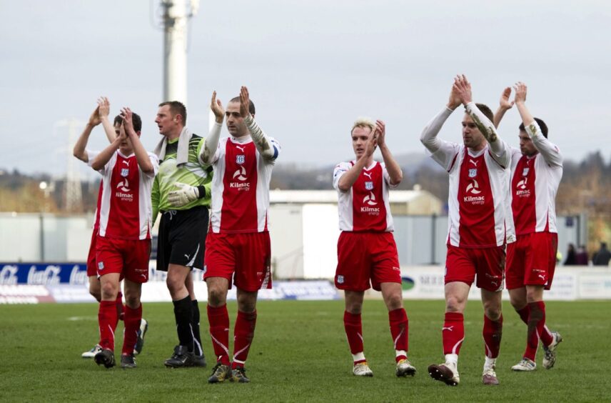 Dundee FC applaud the fans while wearing the 2010-2011 red and white away kit.