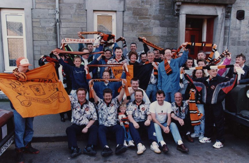 United fans with scraves and flags on a street before the 1994 Scottish Cup final. 