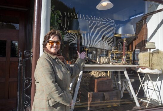 Elaine McConnochie smiling in front of shop window