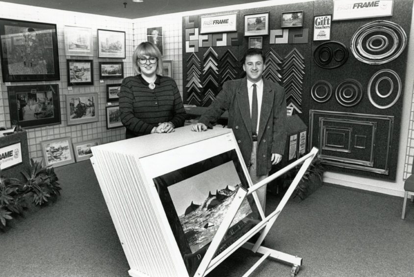 two staff beside a rack of pictures in Fast Frames in Dundee in 1988