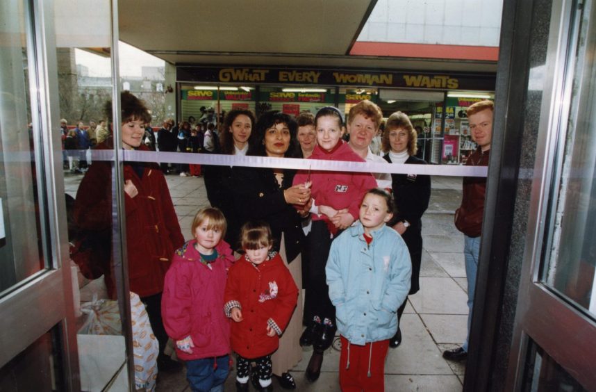 Shoppers and staff at the ribbon cutting in the doorway as part of the What Everyone Wants re-opening ceremony 