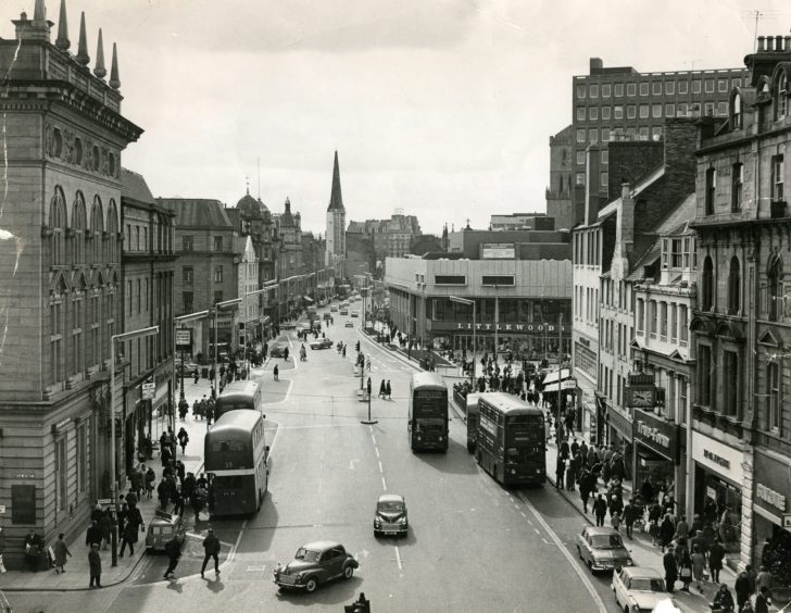 an aerial view showing pedestrians on the old Dundee High Street and many old buses. 