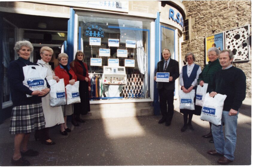 People pose for a picture in front of the store at the charity shop renaming ceremony in March 1995.