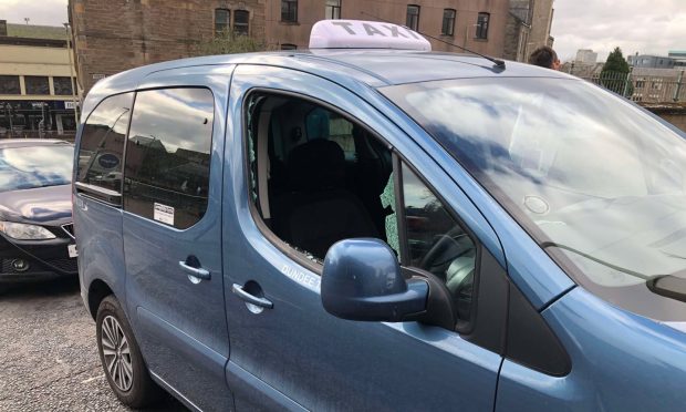 A lout used a boulder to smash their way into a taxi on Hilltown, Dundee. Image Police Scotland