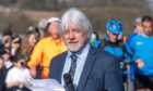 Grant Laing with microphone and speech printed on paper with crowd of children, runners and cyclists behind