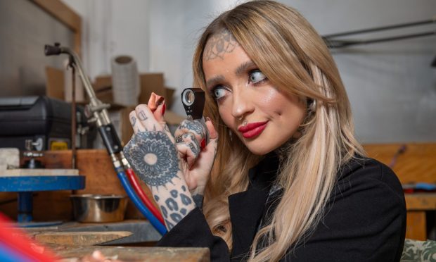 Dr Maria Maclennan uses a microscope to examine a piece of jewellery
