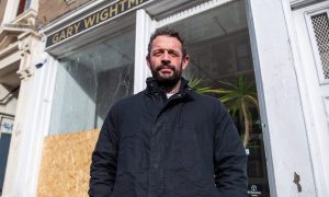 Gary Wightman next to the smashed window of his hairdressing salon on Constitution Road., Dundee.