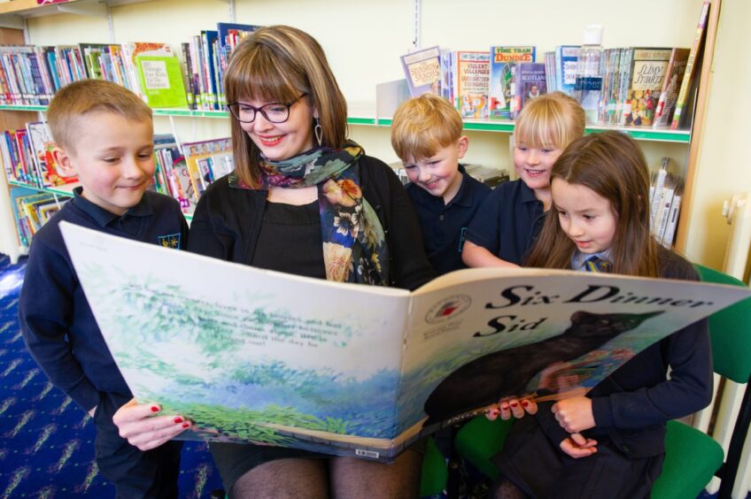 P1 pupils read a book with Anna Stewart.