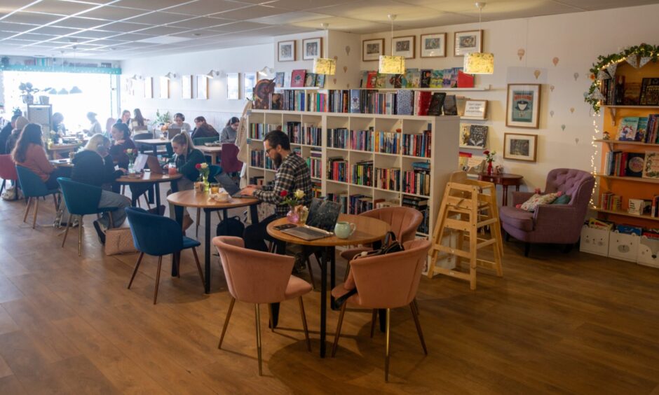 Image shows: Interior shot of The Book Nook cafe and bookshop in Stirling. The busy cafe scene shows visitors at tables and bookshelves.