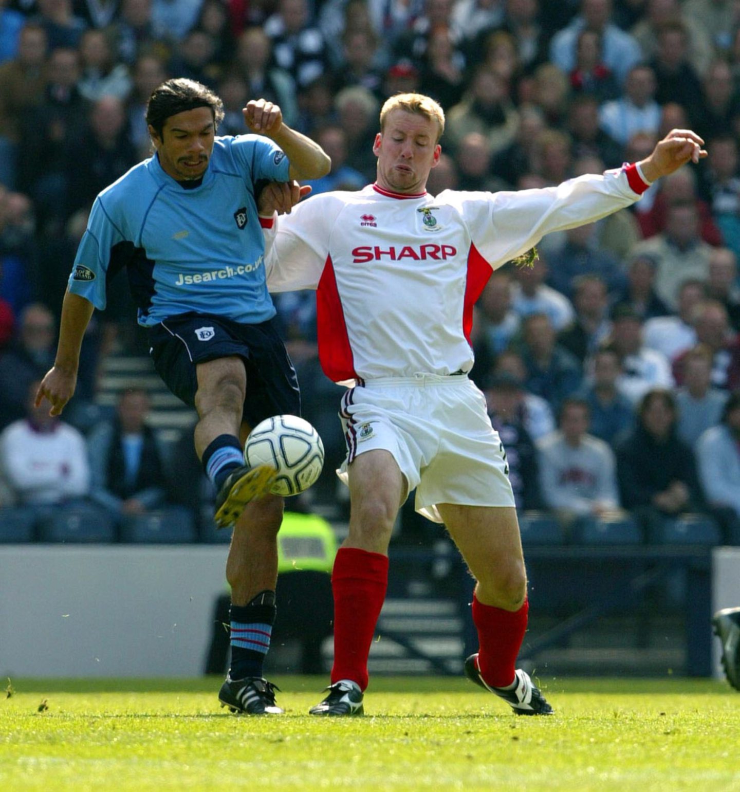 Fabian Caballero kicks the ball while under pressure from an opposing player 