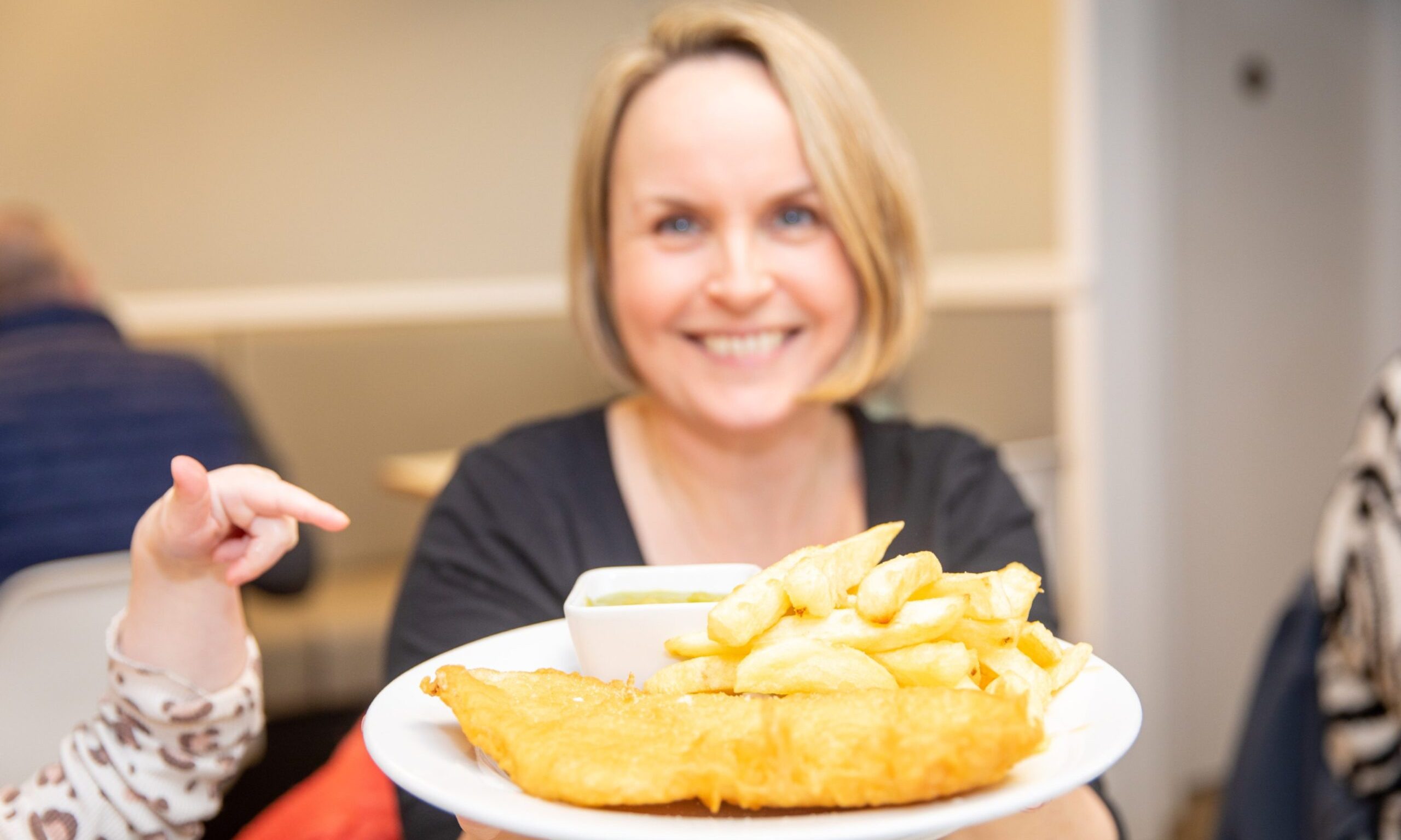 Rachel's daughter Lily tries to grab a chip from her gluten-free haddock supper at Jim Jack's in Dunfermline. Image: Steve Brown/DC Thomson