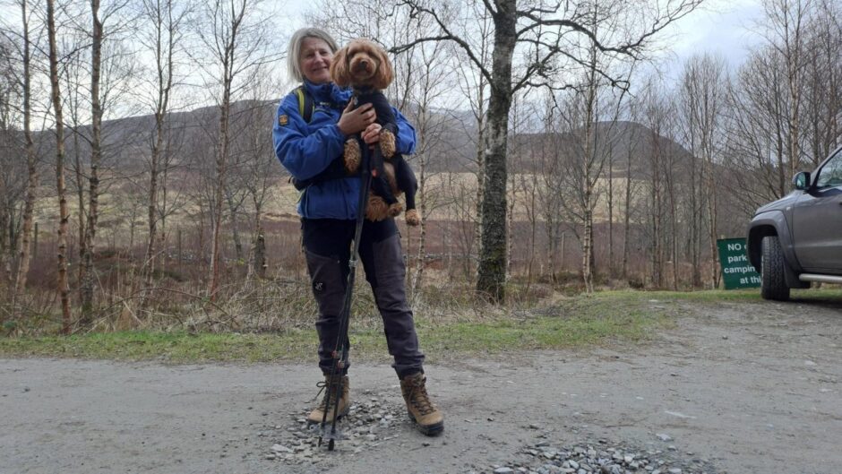 Leanne Haining in walking gear holding dog at car park at Schiehallion