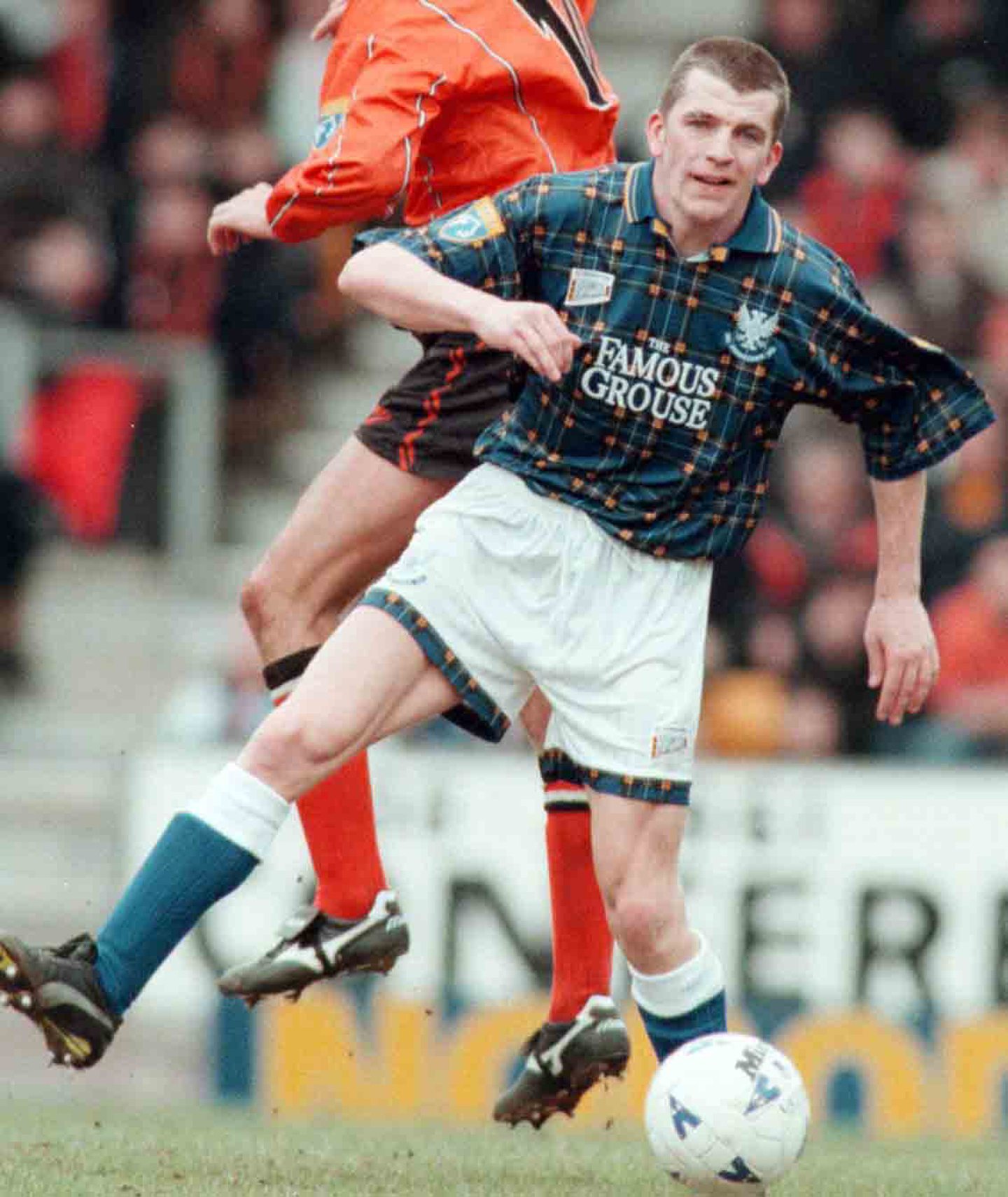 Jim Weir challenges a Dundee United player for the ball