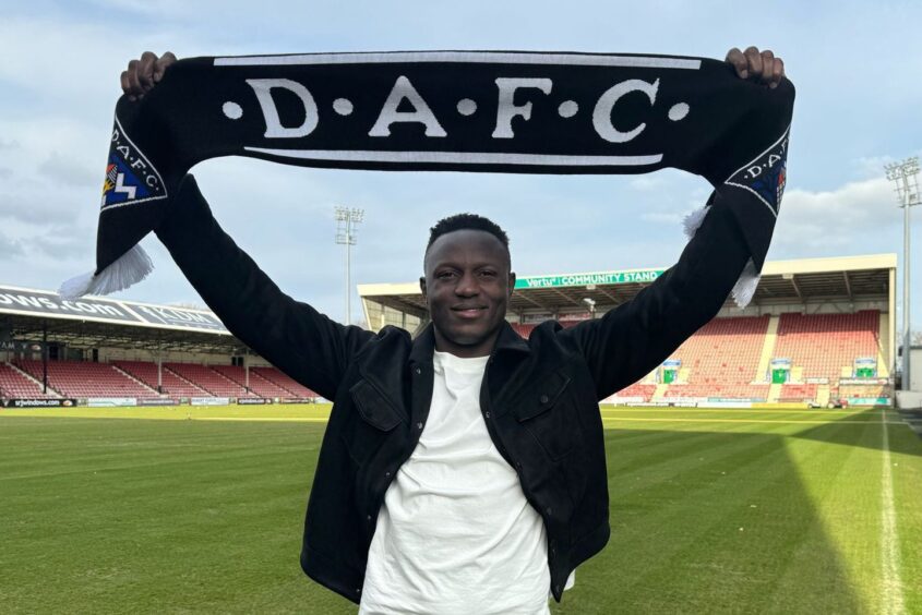 Victor Wanyama holds up a DAFC scarf.