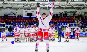 Captain Sam McCluskey holds aloft the league title trophy in front of his Dundee Rockets teammates.