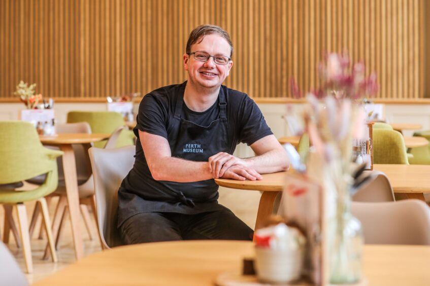 Matt Wester smiling seated at table in Perth Museum cafe