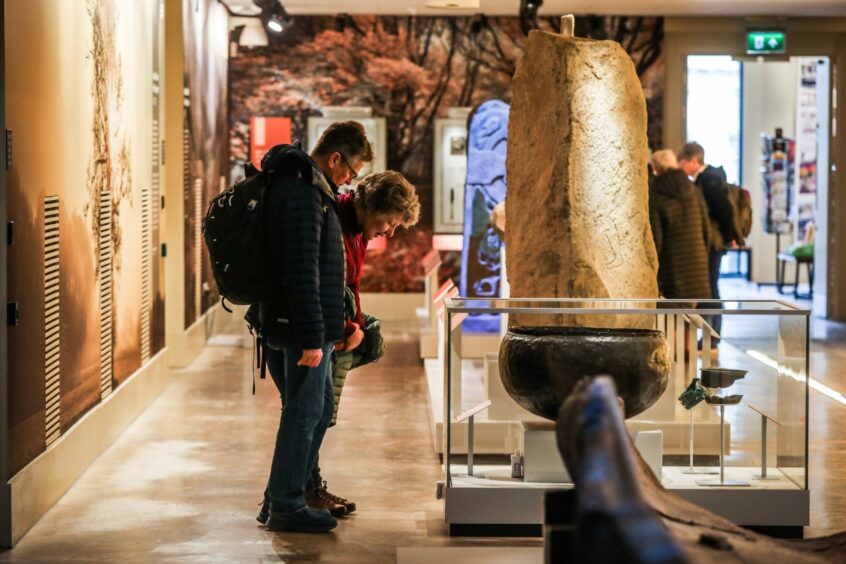 Visitors looking at standing stone exhibits at Perth Museum