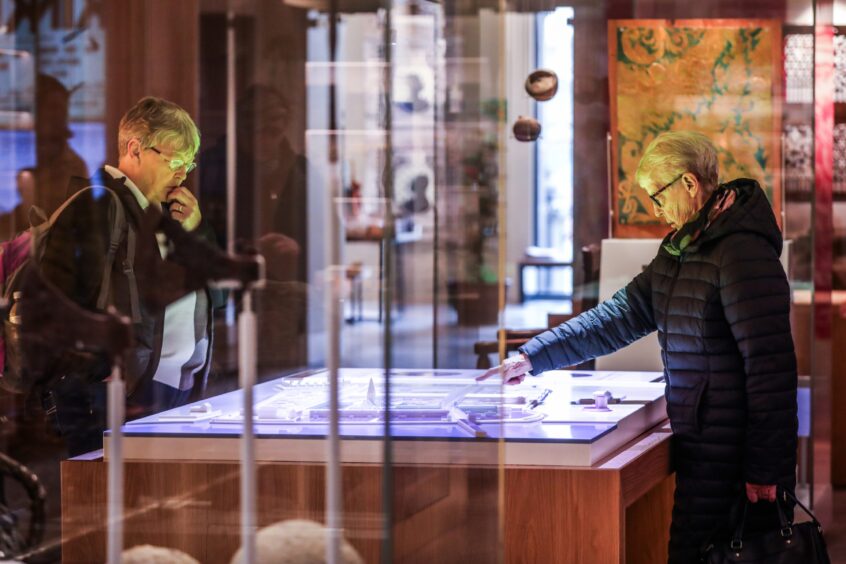 Two women pointing at display case in Perth Museum