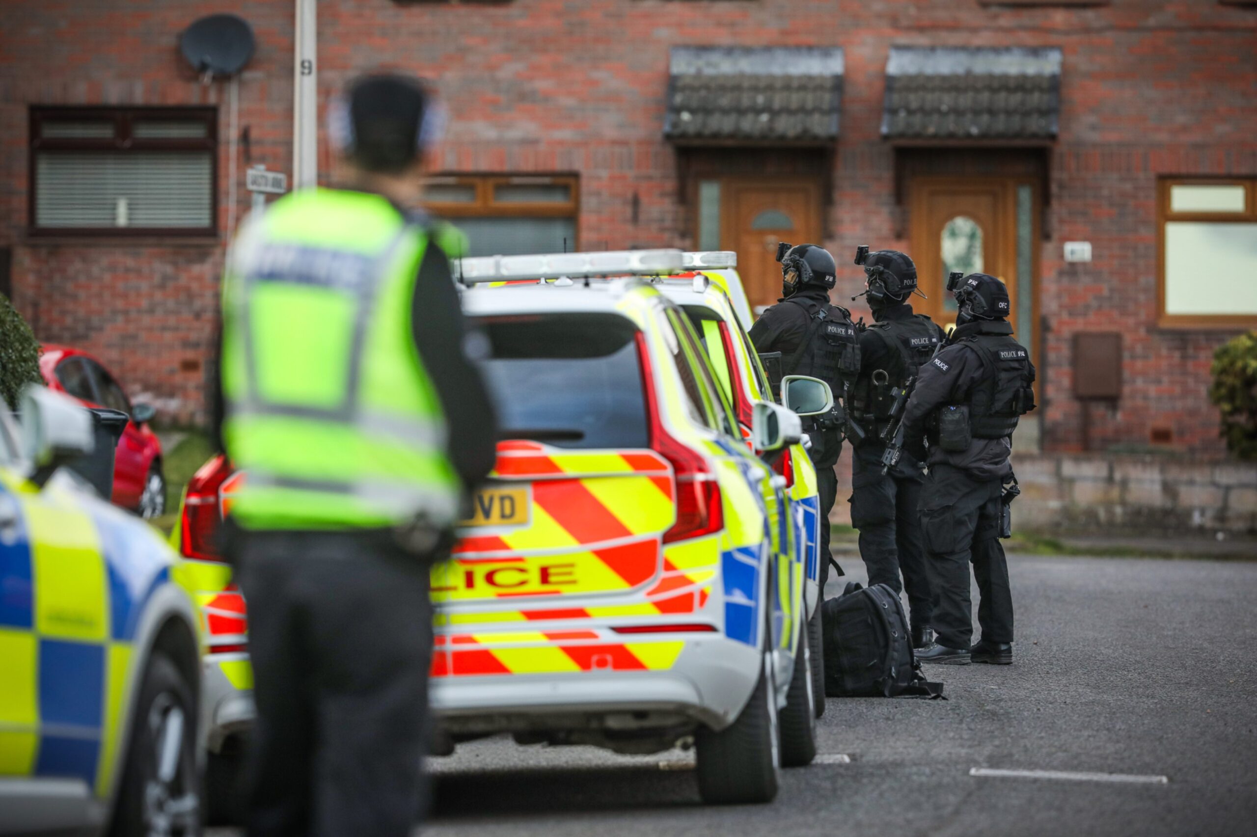 Uniformed police and armed officers in the street.