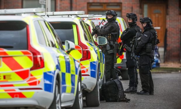 Armed police outside the house on Earlston Avenue in Dundee.