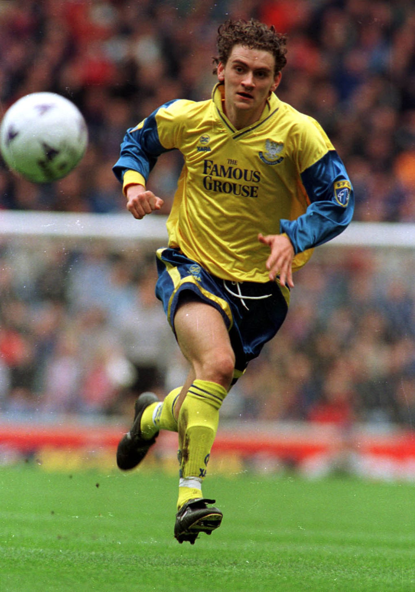 Gerry McMahon running in the Famous Grouse yellow away kit in 1998.