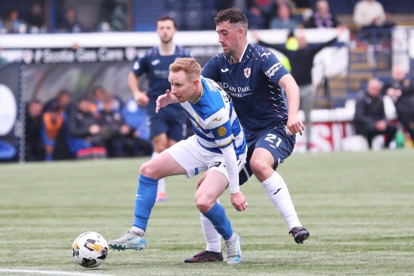 Raith midfielder Shaun Byrne challenges from behind as Morton's Ali Crawford shields the ball.